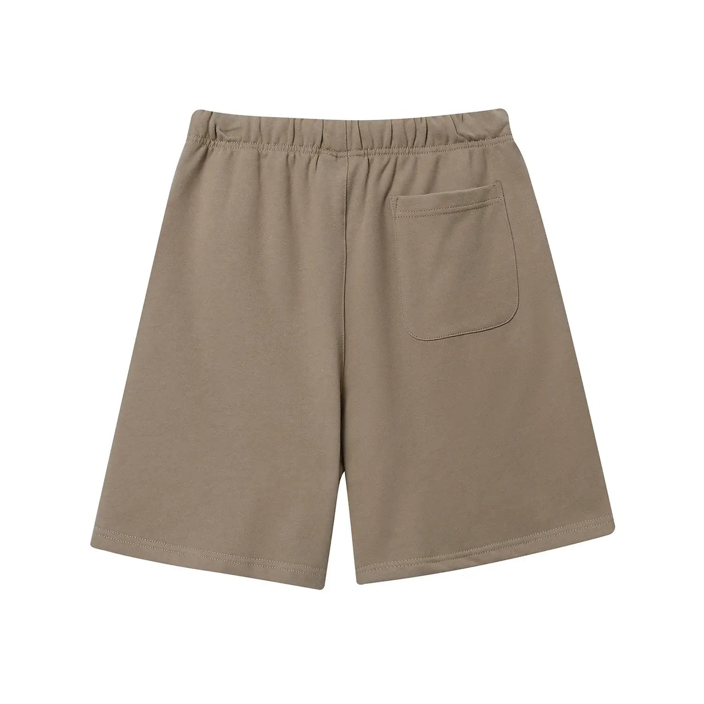 Model wearing Fear of God ESSENTIALS Sandrift shorts in neutral beige color