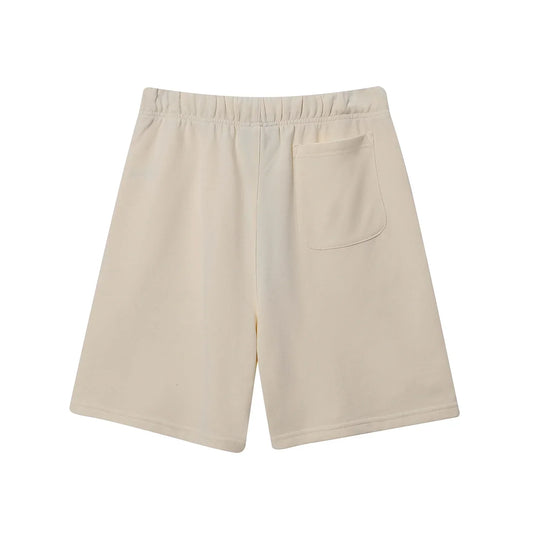 Fear of God Essentials light cream fleece shorts with tonal branding and relaxed silhouette
