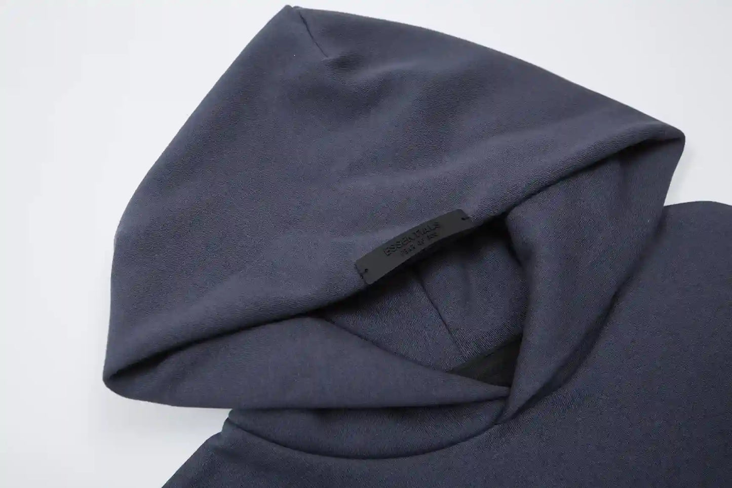Close-up of Essentials blue hoodie fleece texture and rubberized logo bar