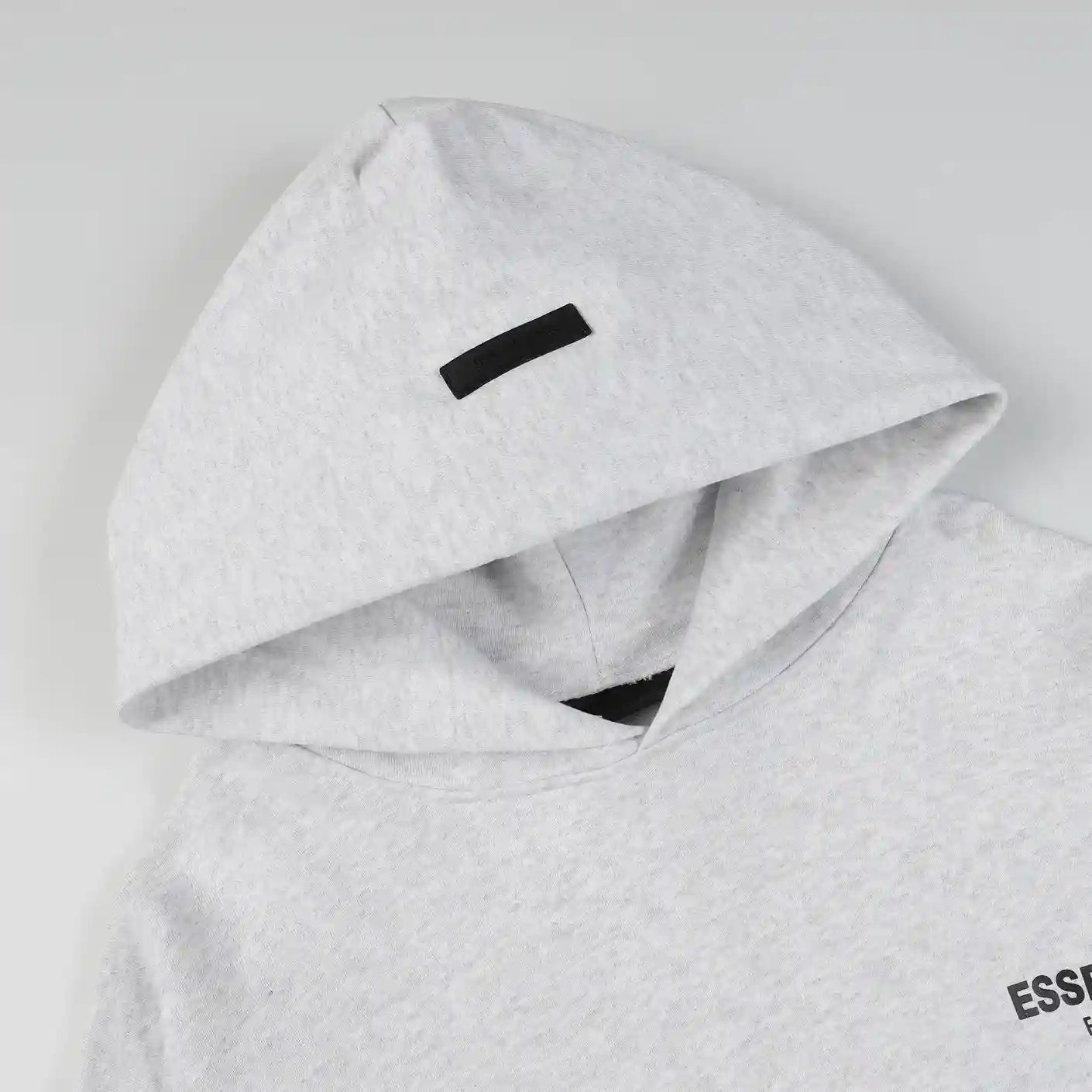 Fear of God Essentials light heather oatmeal hoodie hood label detail