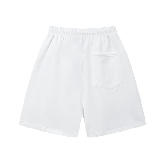 Model wearing Fear of God Essentials Eggshell Beige Shorts, showing relaxed fit and subtle ESSENTIALS logo detail.