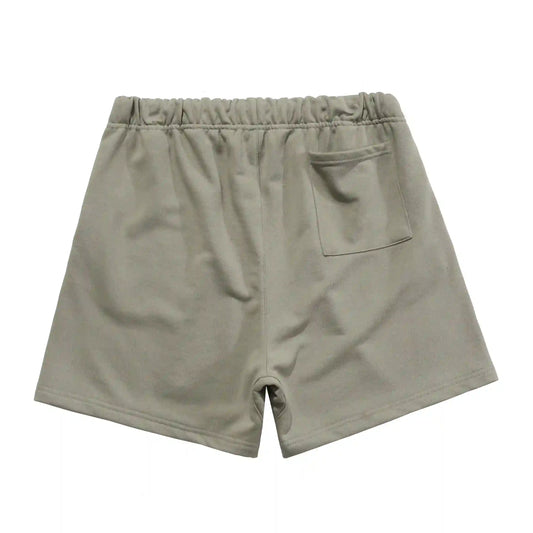 Front view of Fear of God Essentials heather grey sweat shorts with drawstring waistband and logo patch.