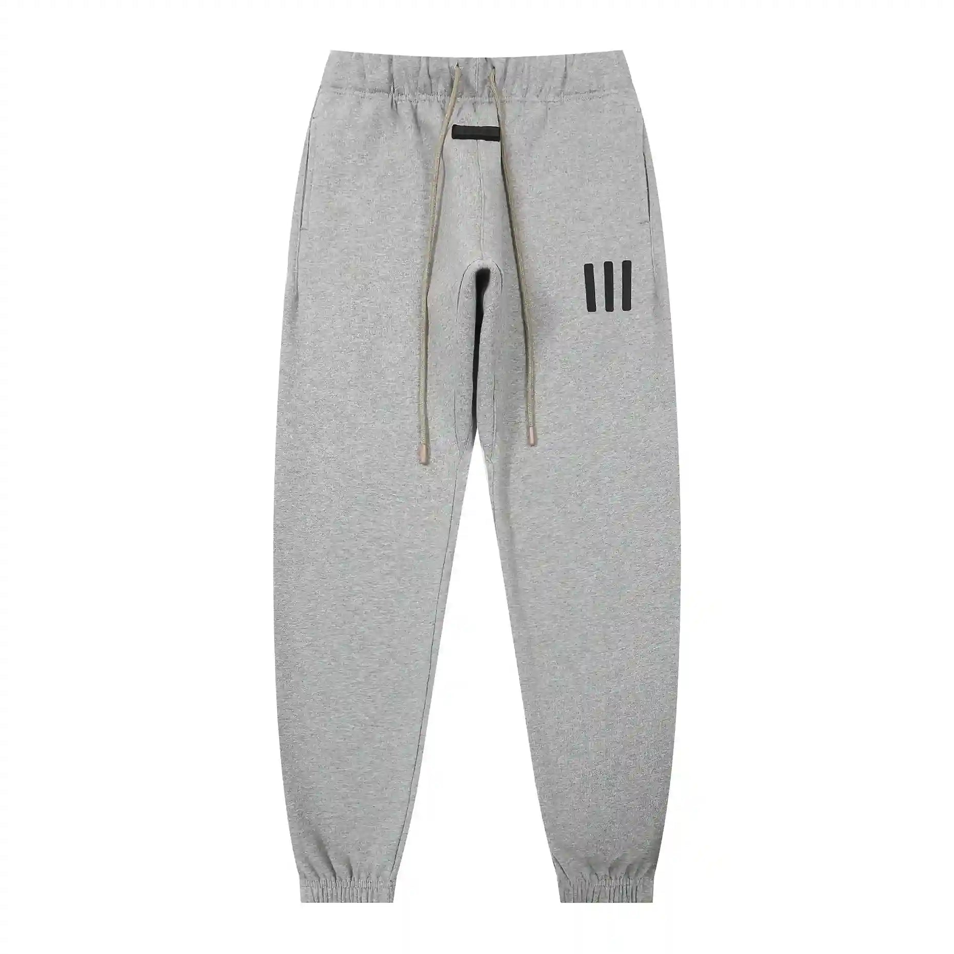 Dark heather oatmeal Essentials joggers soft-touch rubberized logo on leg close-up