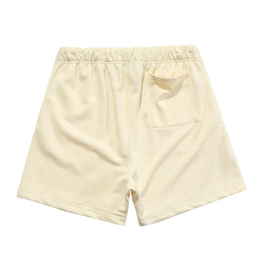 Fear of God Essentials light cream fleece shorts with tonal branding and relaxed fit