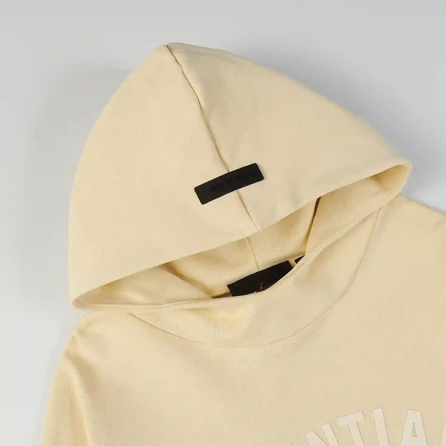 Close-up of Essentials Calm Shell hoodie fleece texture and rubberized logo bar
