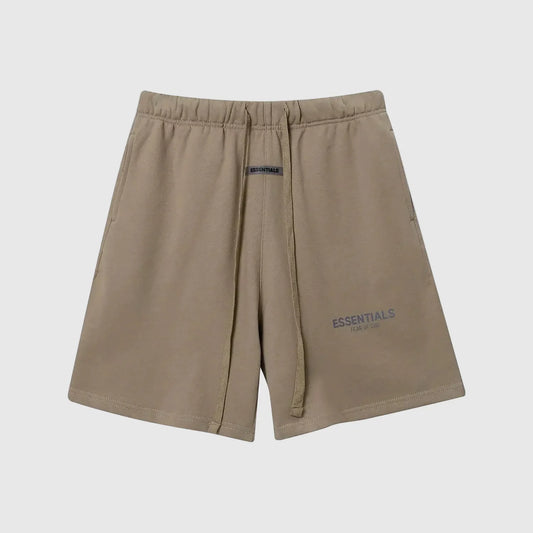 Model wearing Fear of God ESSENTIALS Sandrift shorts in neutral beige color
