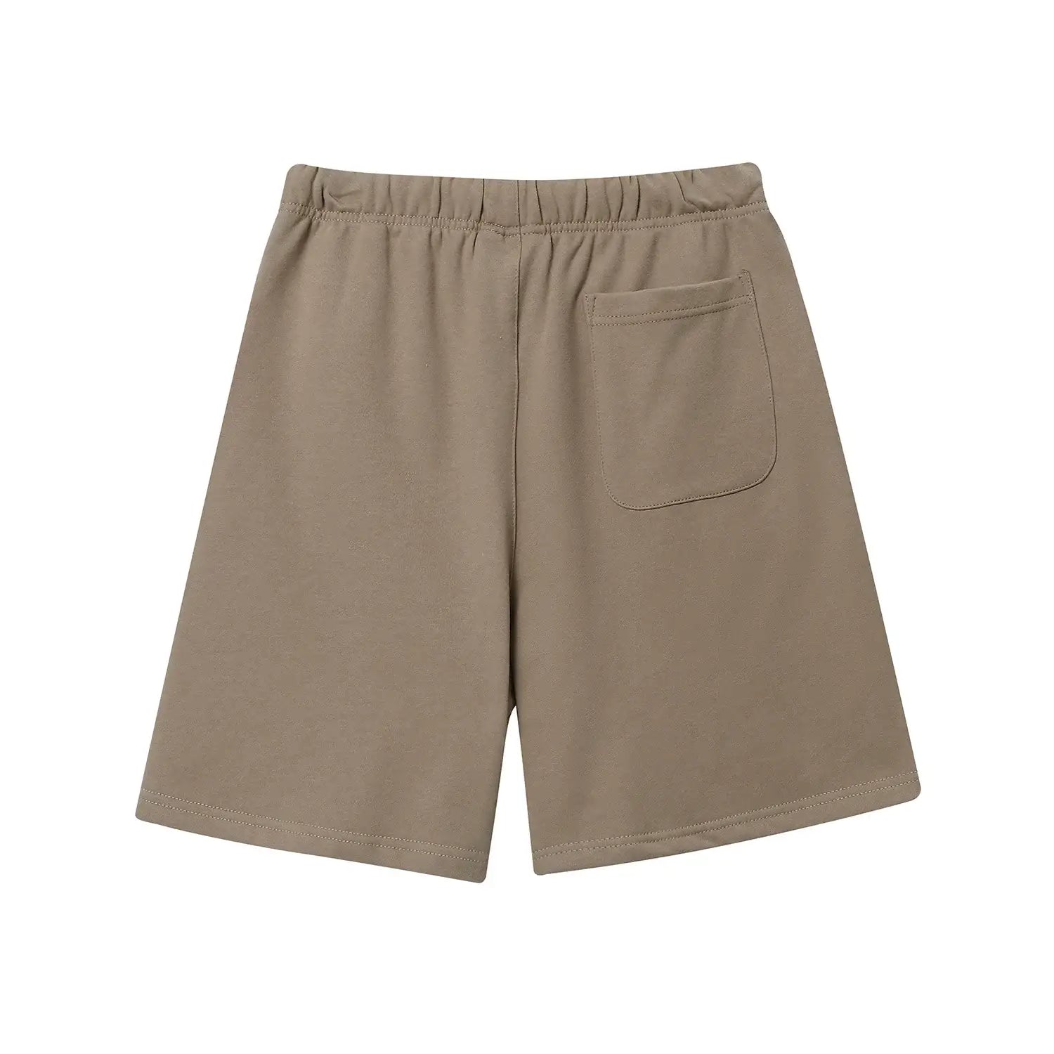 Model wearing Fear of God ESSENTIALS Sandrift shorts in neutral beige color