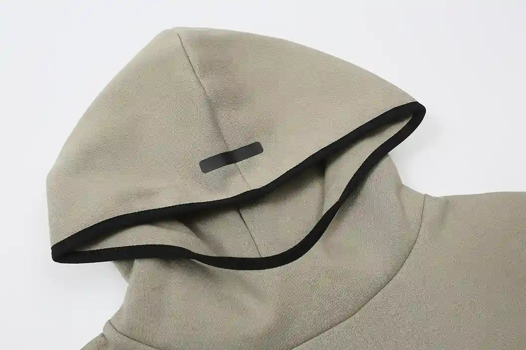 Close-up of cement hoodie fleece texture and rubberized Essentials logo bar