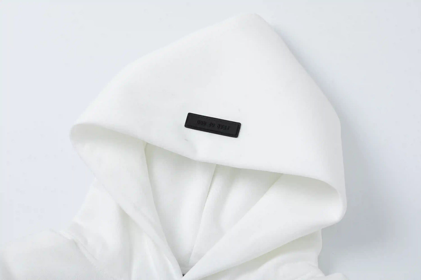 Close-up of Cloud Dance hoodie fleece texture and rubberized Essentials logo bar