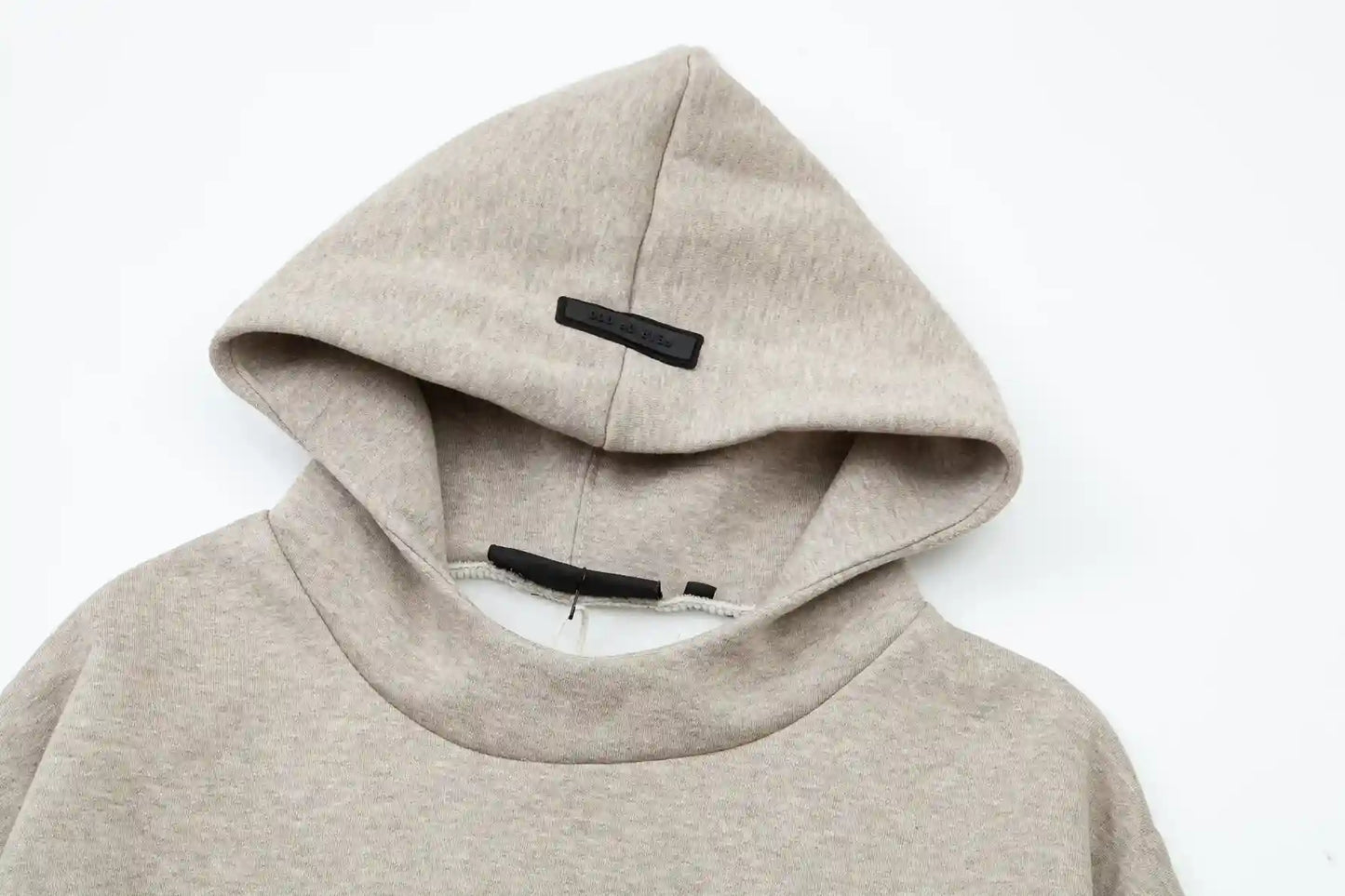 Fear of God Essentials heathered grey hoodie front view with rubberized black bar branding