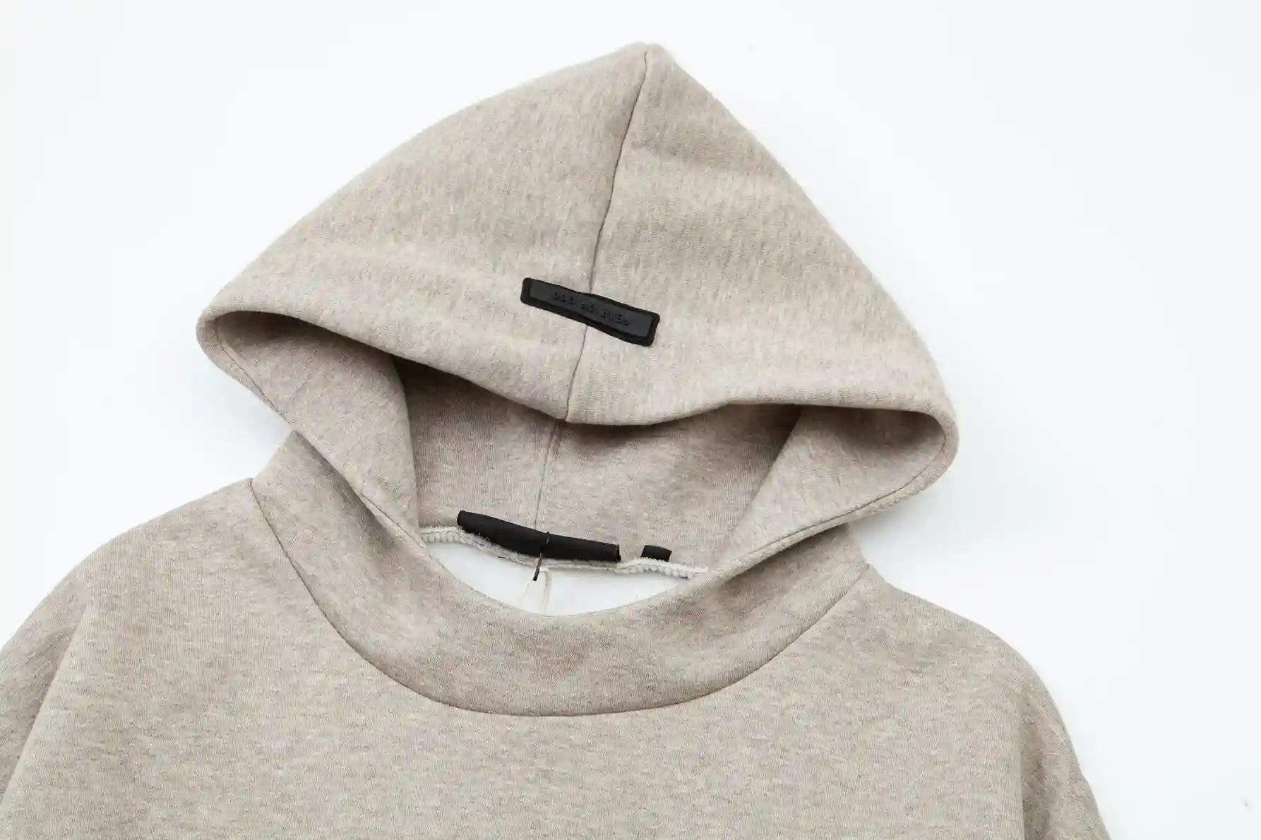 Fear of God Essentials heathered grey hoodie front view with rubberized black bar branding