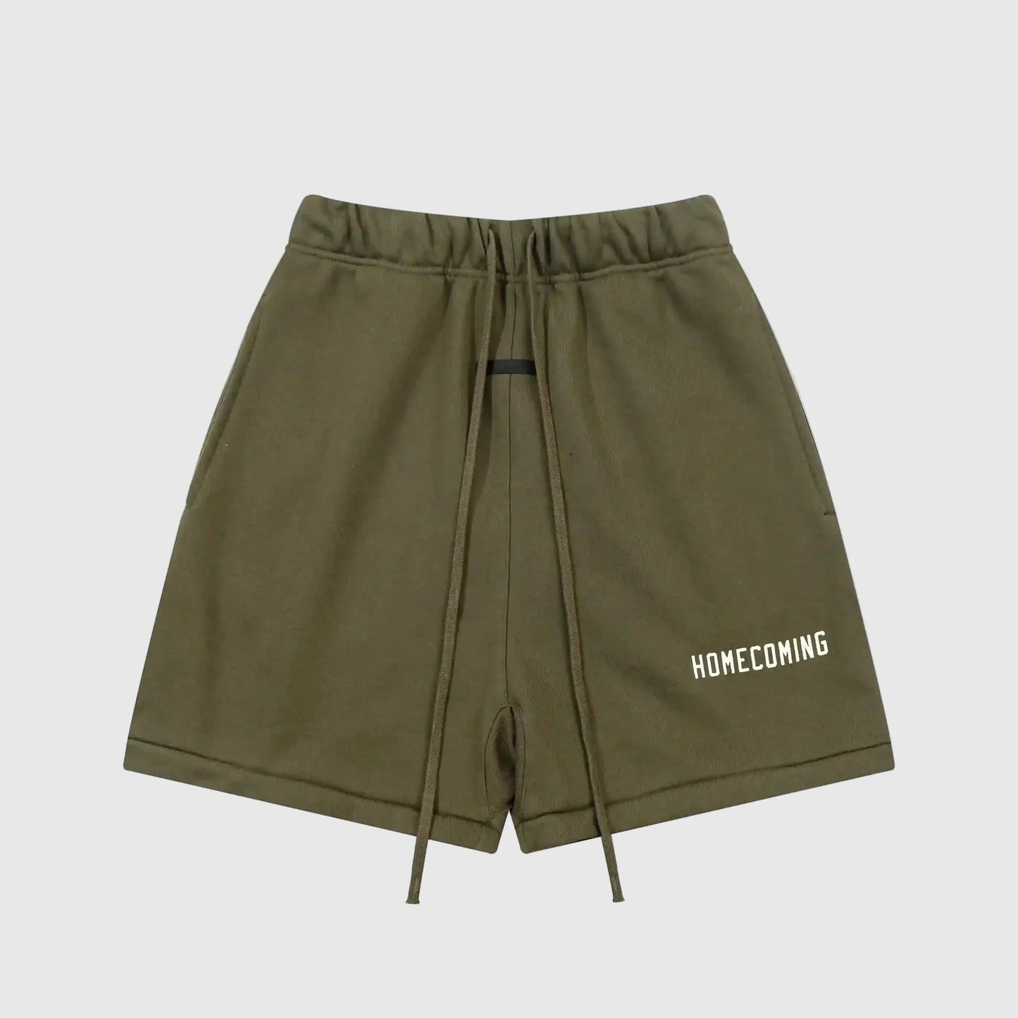 Front view of green Fear of God Essentials Hemlock shorts with elastic waistband