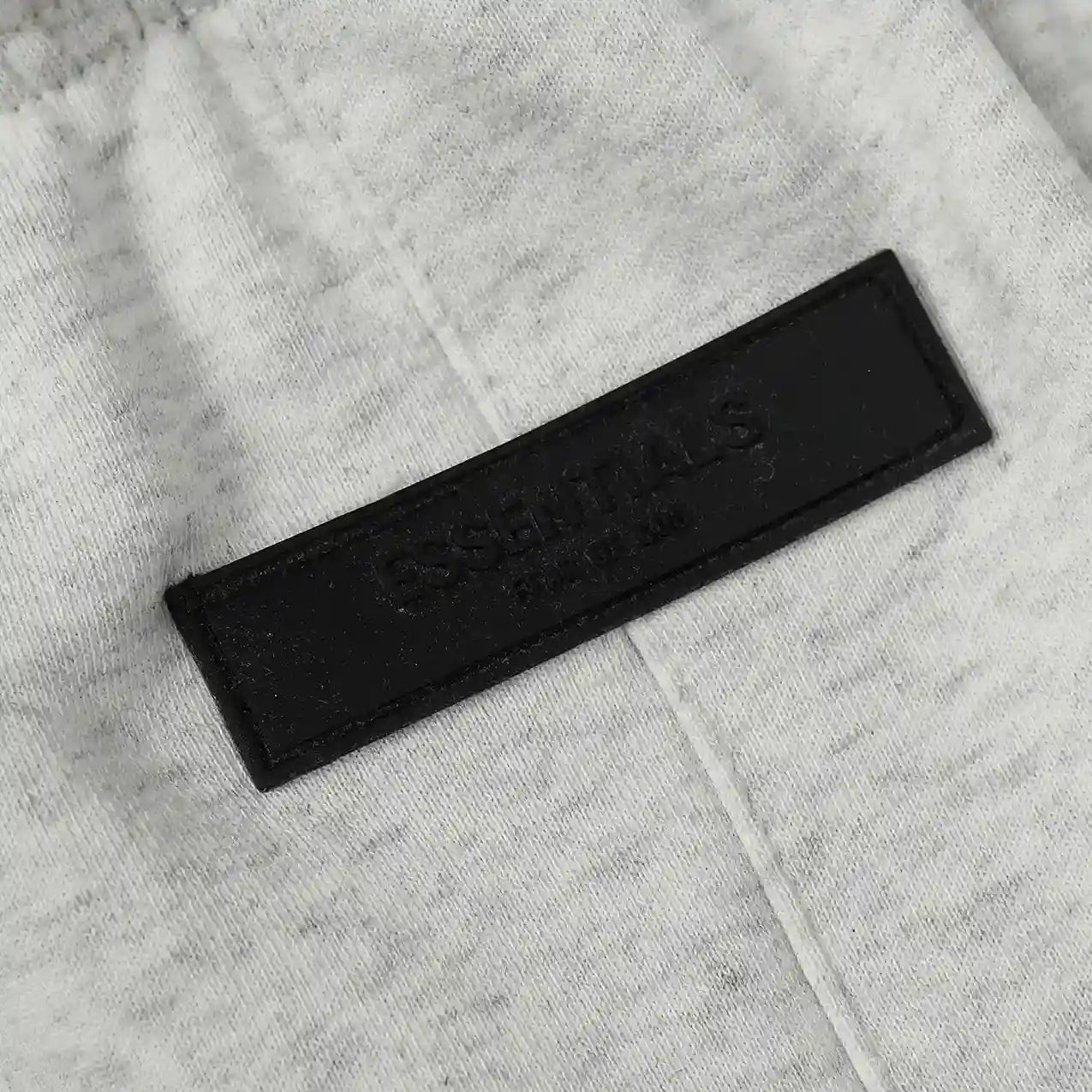 Fear of God Essentials light heather oatmeal fleece shorts with tonal branding and relaxed silhouette