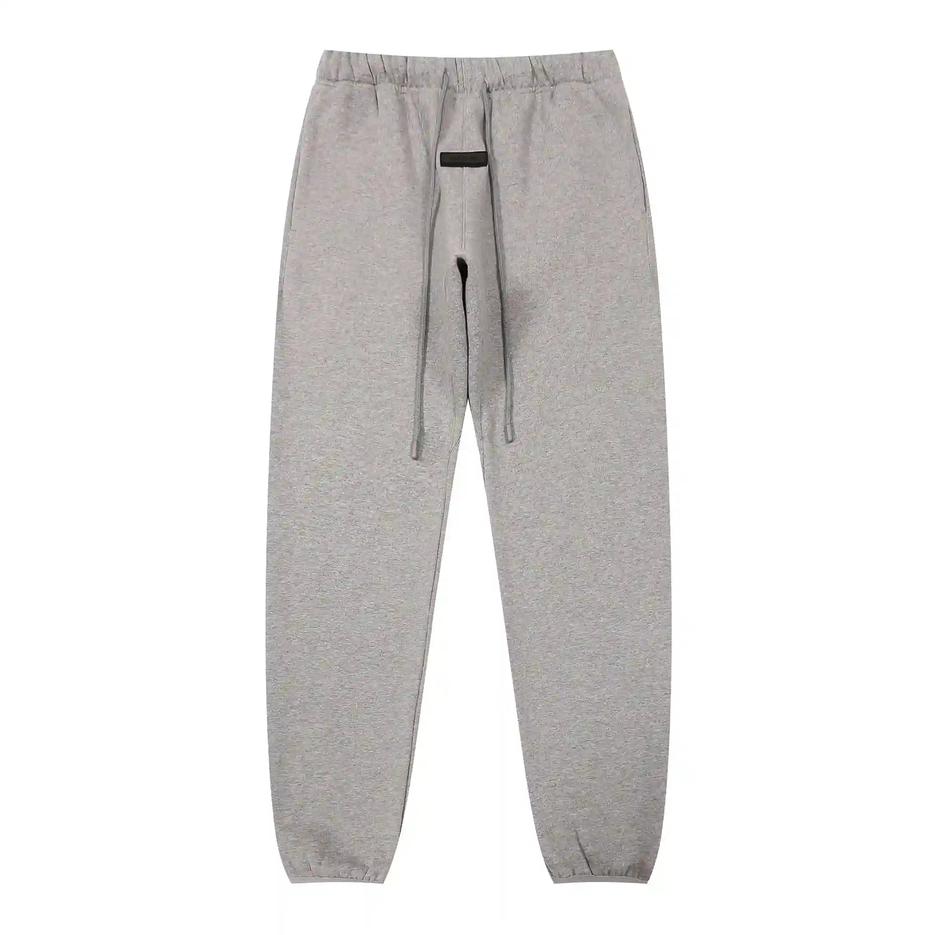 Dark heather oatmeal Essentials joggers soft-touch rubberized logo on leg close-up