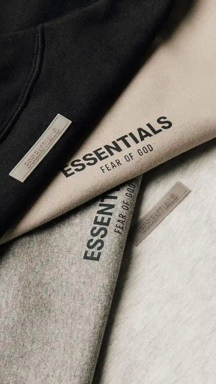 Two pieces of clothing with 'Essentials Fear of God' branding on a neutral background.