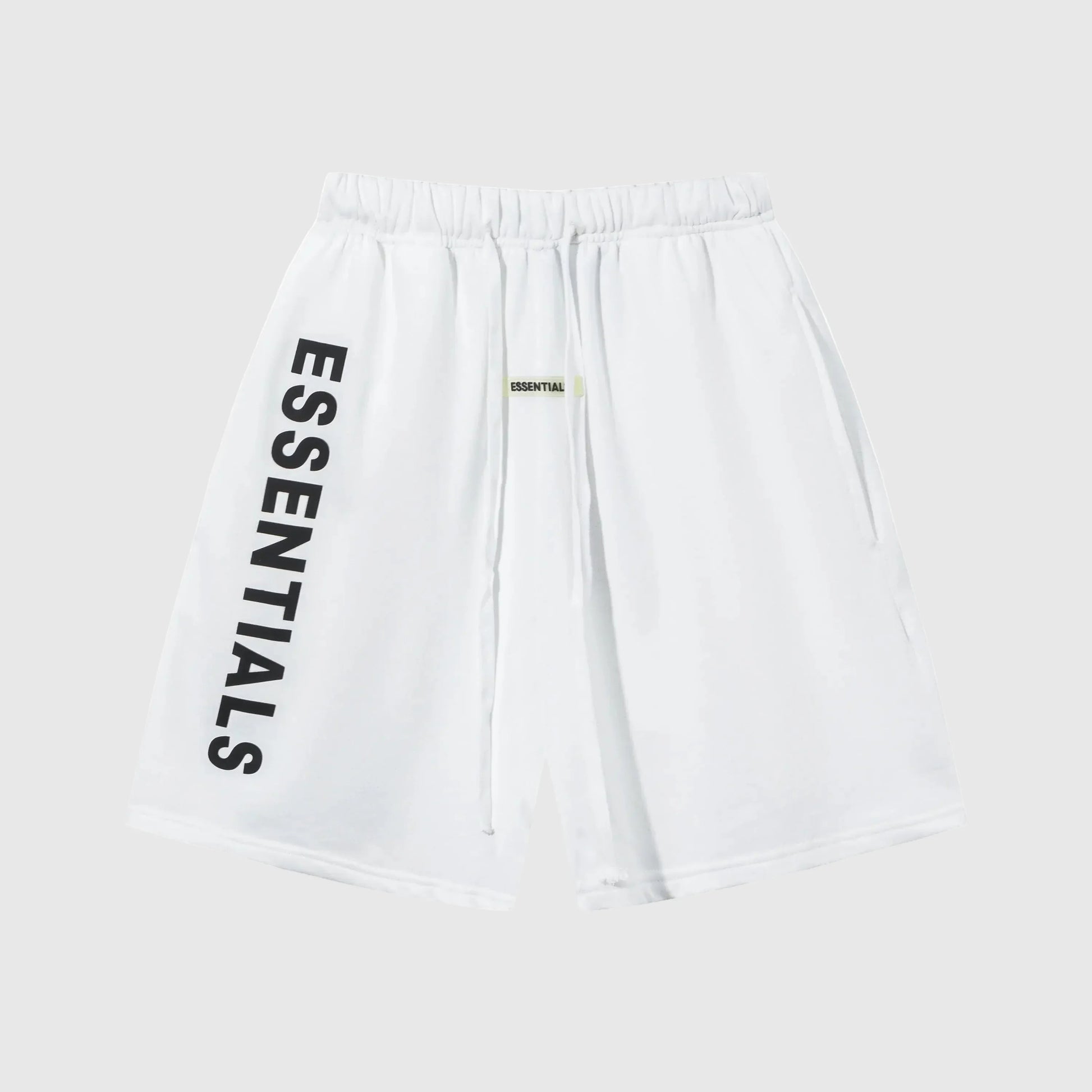 Model wearing Fear of God Essentials Eggshell Beige Shorts, showing relaxed fit and subtle ESSENTIALS logo detail.